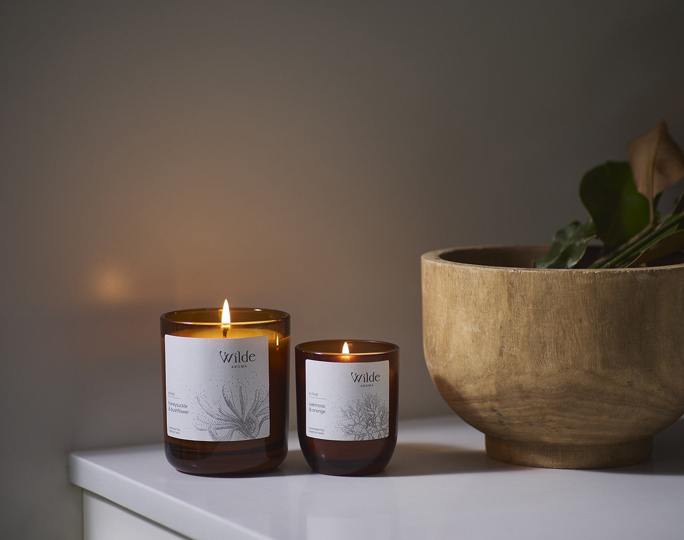 Wilde Aroma small and large soy candle lit on kitchen bench